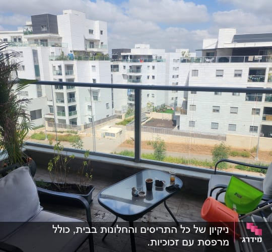 מרפסת עם כיסאות ושולחן, נוף לבניינים